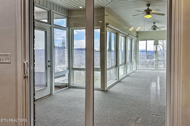 unfurnished sunroom with a ceiling fan