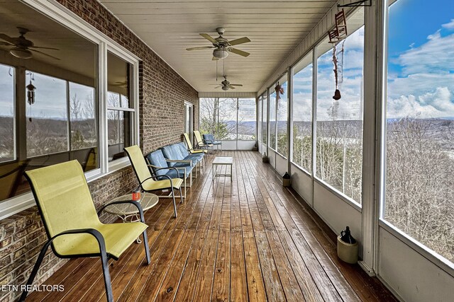 unfurnished sunroom featuring a ceiling fan