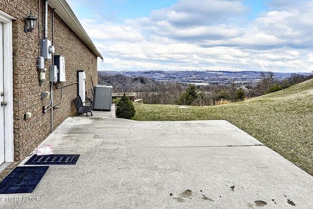 view of patio / terrace featuring central air condition unit and a mountain view