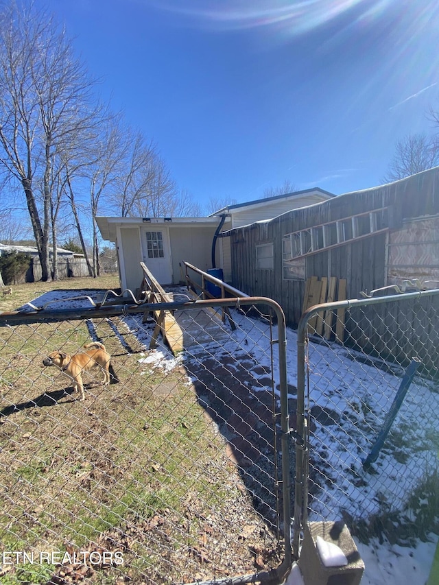 back of house featuring fence and a gate