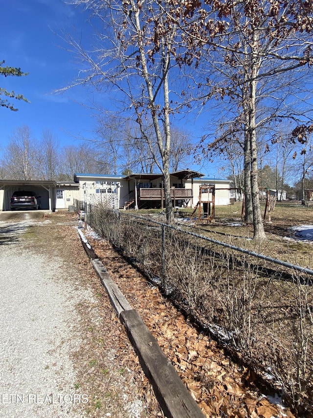 view of front of property featuring driveway, a carport, and fence