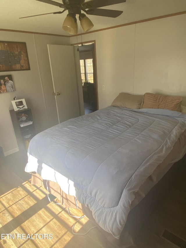 bedroom with ornamental molding and ceiling fan