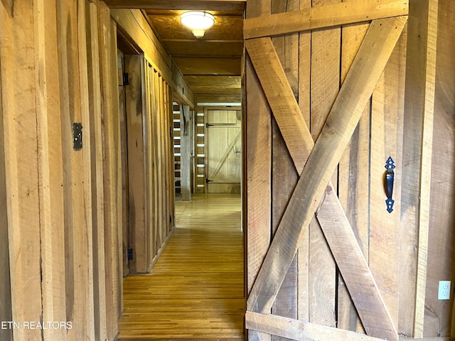 hallway with wooden walls and wood finished floors