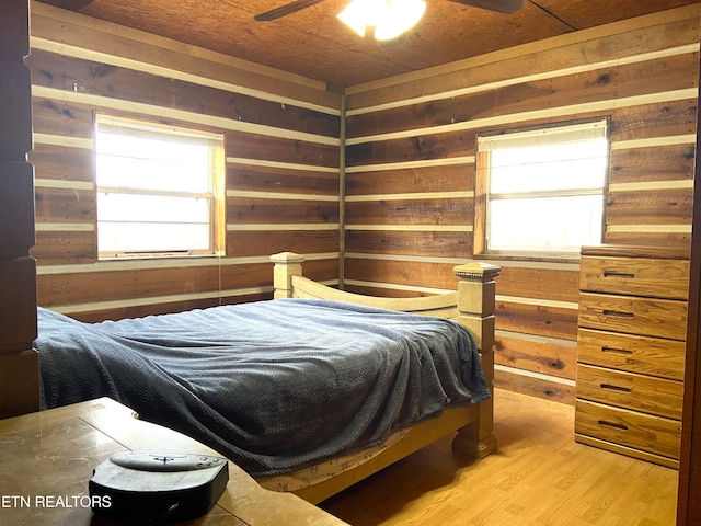 bedroom with wood walls and wood finished floors