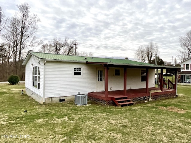 back of property with a lawn, metal roof, crawl space, covered porch, and central air condition unit