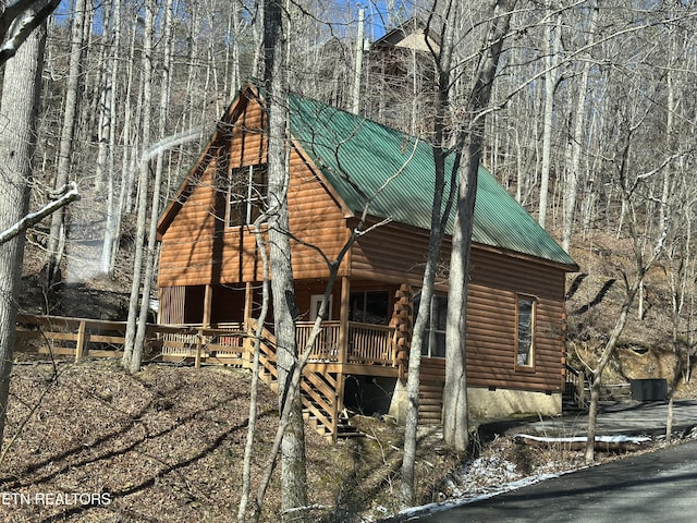 view of front of property featuring crawl space, stairway, and metal roof