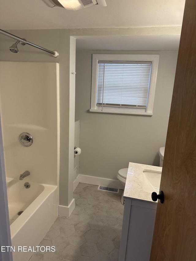 full bath featuring visible vents, toilet, washtub / shower combination, vanity, and baseboards