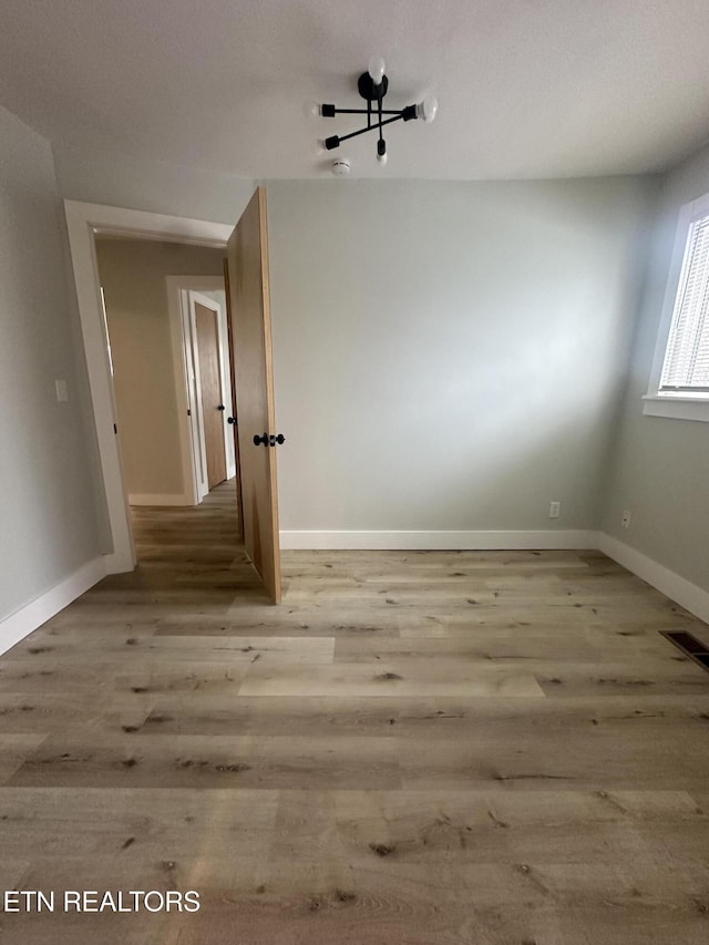 unfurnished room featuring light wood finished floors and baseboards