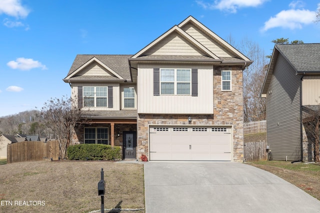 view of front of home with a garage, concrete driveway, fence, and stone siding