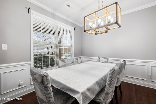 dining room featuring a wainscoted wall, dark wood finished floors, and crown molding