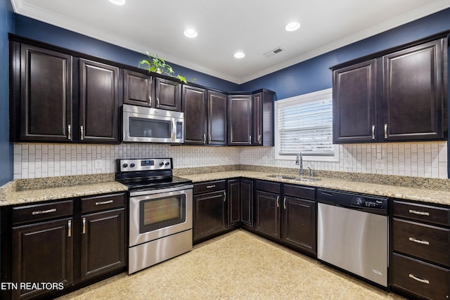 kitchen with stainless steel appliances, visible vents, decorative backsplash, a sink, and light stone countertops