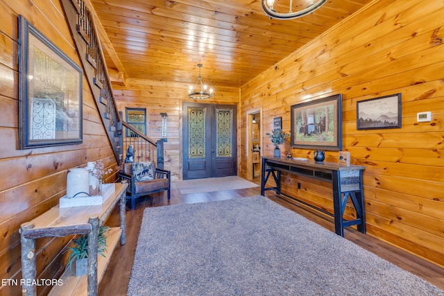 entrance foyer with a notable chandelier, wood ceiling, stairway, and wood finished floors