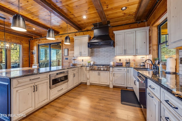 kitchen with appliances with stainless steel finishes, wood ceiling, a peninsula, and custom exhaust hood