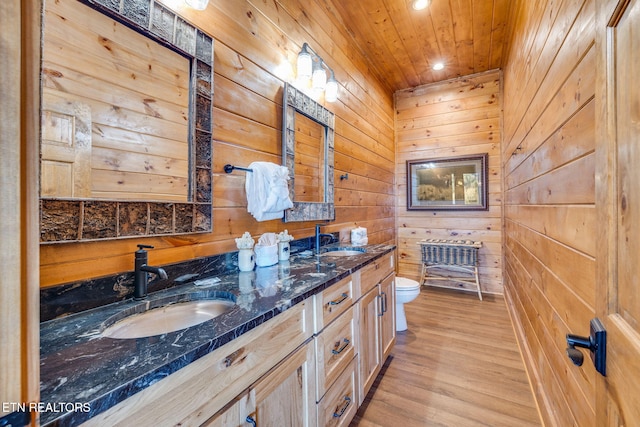 full bath featuring toilet, wood walls, wood finished floors, wood ceiling, and a sink