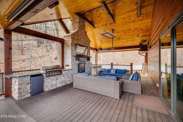 wooden deck with an outdoor kitchen, grilling area, and an outdoor living space with a fireplace