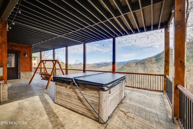 interior space with a hot tub and a mountain view