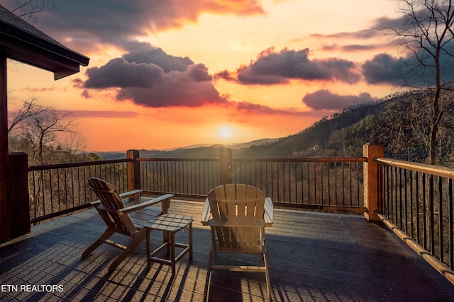 deck at dusk featuring a mountain view