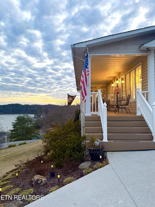353 Southshore Dr, Greenback, TN 37742 - exterior entry at dusk featuring covered porch and a water view