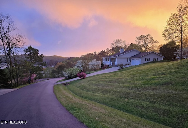 353 Southshore Dr, Greenback, TN 37742 - view of front facade with asphalt driveway, a chimney, a front lawn, and an attached garage