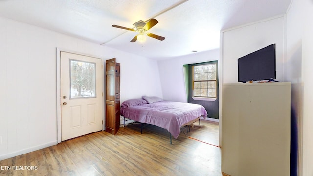 bedroom with ceiling fan, baseboards, and wood finished floors