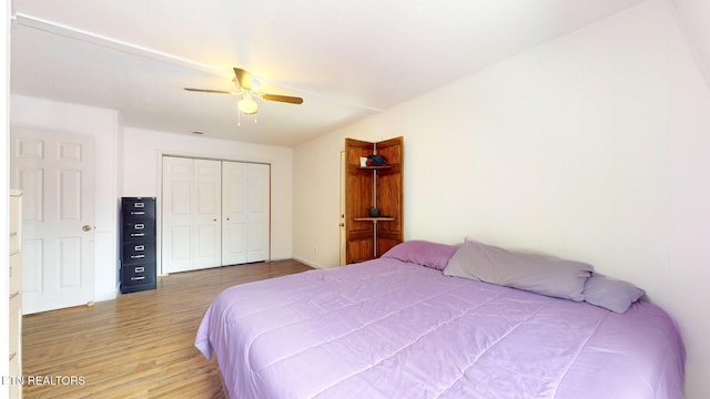 bedroom with a closet, light wood-type flooring, and a ceiling fan