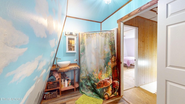 bathroom featuring crown molding, wood finished floors, a sink, and curtained shower