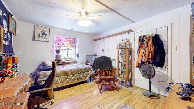 bedroom featuring a textured ceiling, ceiling fan, and wood finished floors