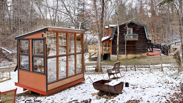 exterior space featuring an outdoor structure, a greenhouse, and a gambrel roof