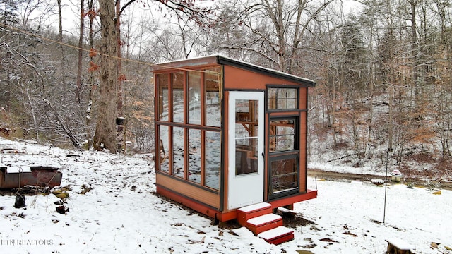 snow covered structure with an outdoor structure