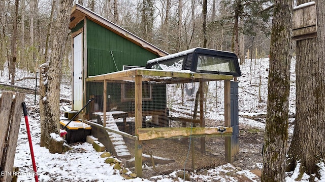 snow covered structure featuring an outdoor structure and exterior structure