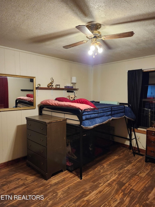 bedroom with a textured ceiling, a ceiling fan, and wood finished floors