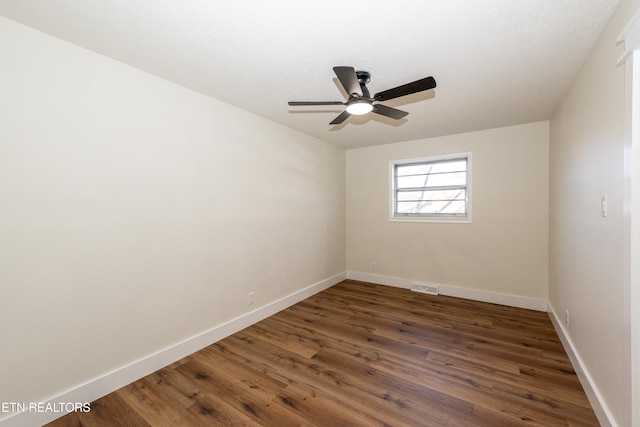 empty room featuring baseboards, visible vents, ceiling fan, and wood finished floors