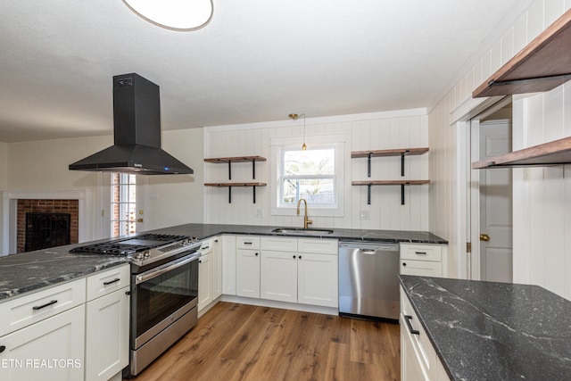 kitchen featuring island exhaust hood, open shelves, stainless steel appliances, a sink, and wood finished floors