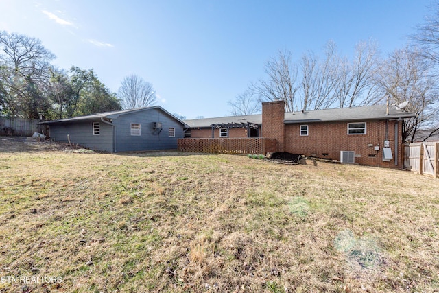 back of house featuring crawl space, a yard, fence, and brick siding