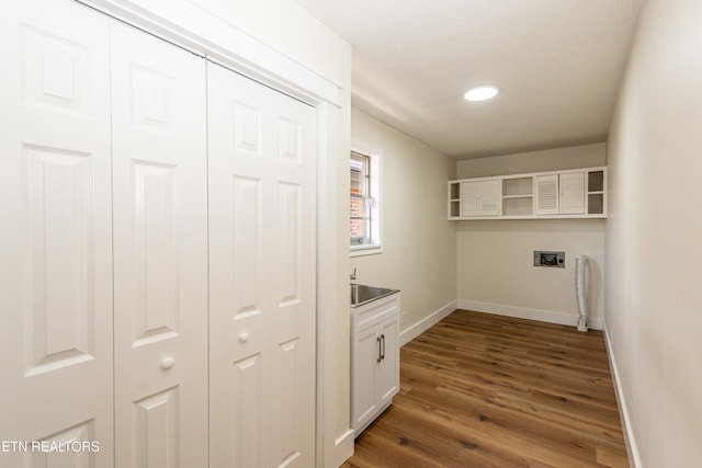 laundry room with washer hookup, dark wood finished floors, cabinet space, and baseboards