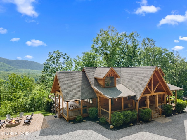 3859 Clabo Mountain Ln, Sevierville, TN 37862 - log-style house featuring a fire pit, a shingled roof, a mountain view, covered porch, and gravel driveway