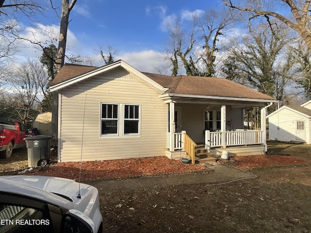 view of front of home featuring a shingled roof and covered porch