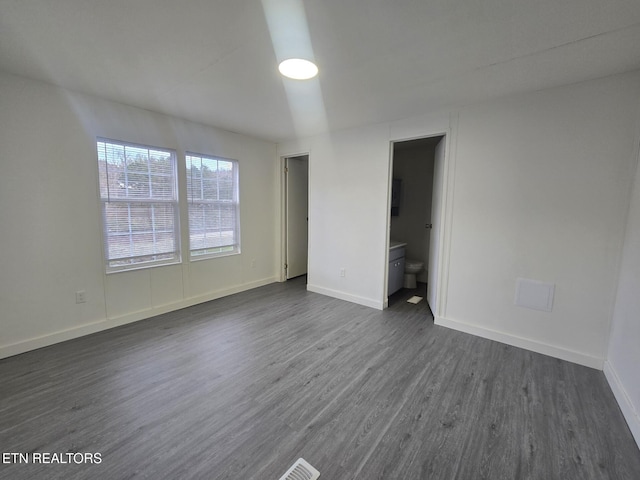 empty room featuring dark wood-style floors and baseboards