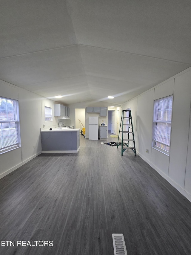 interior space with dark wood-style floors, visible vents, and baseboards