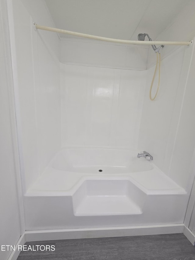 bathroom with a shower and wood finished floors