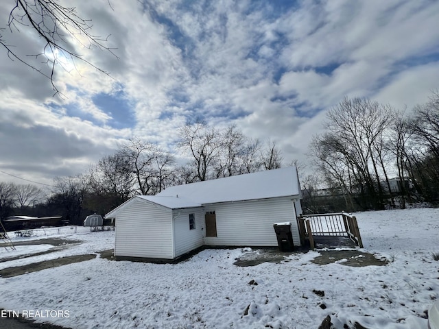 view of snow covered back of property