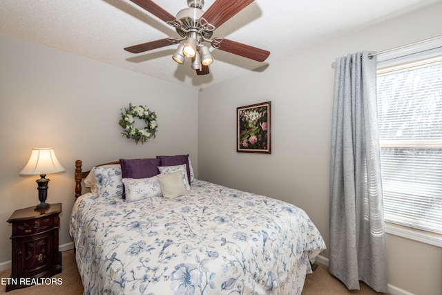 carpeted bedroom featuring baseboards and a ceiling fan