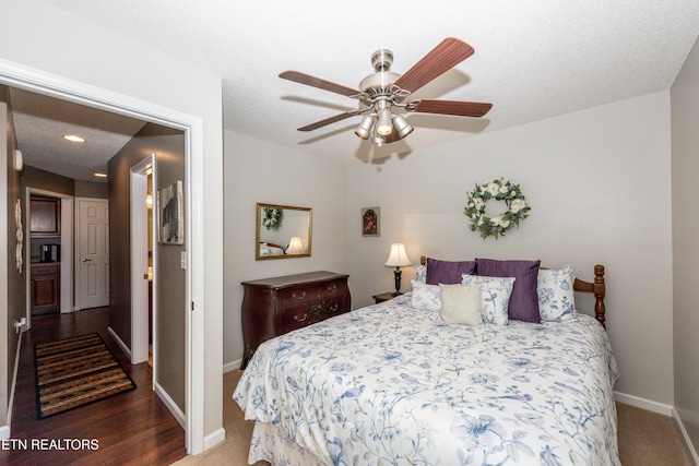 bedroom with a textured ceiling, baseboards, and a ceiling fan