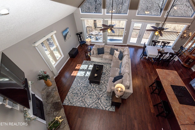 living area with ceiling fan, plenty of natural light, and wood finished floors