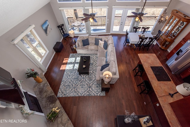 living area featuring a ceiling fan, wood-type flooring, and plenty of natural light