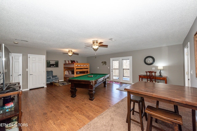 game room featuring a textured ceiling, pool table, wood finished floors, and visible vents