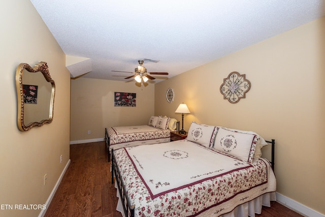 bedroom featuring dark wood-style flooring, visible vents, ceiling fan, and baseboards