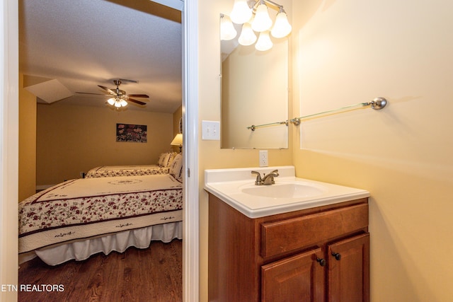 bathroom with connected bathroom, a ceiling fan, wood finished floors, and vanity