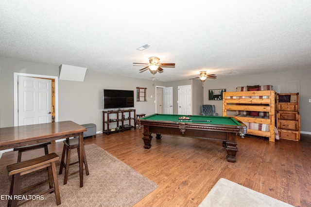 playroom with a textured ceiling, ceiling fan, pool table, wood finished floors, and visible vents