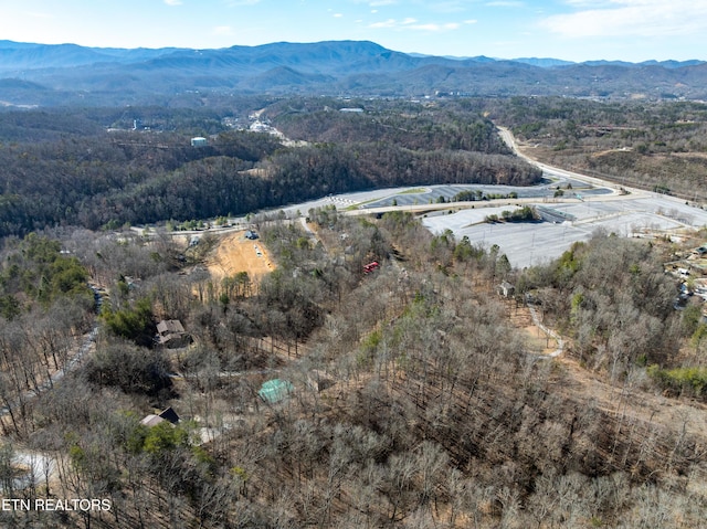 drone / aerial view featuring a wooded view and a mountain view